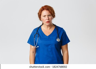 Medicine, Healthcare And Coronavirus Concept. Frustrated And Confused Redhead Middle-aged Doctor, Female Nurse Cant Understand Something, Looking At Camera And Frowning Puzzled