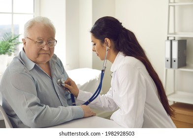 Medicine, Healthcare And Insurance For Elderly, Preventive Measures To Avoid Cardiac Disease. Young Female Doctor Checking Retired Gentleman Lungs With Stethoscope At Hospital Office