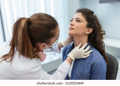 medicine, healthcare and medical exam concept - doctor or nurse checking patient's tonsils at hospital. Endocrinologist examining throat of young woman in clinic - Powered by Shutterstock