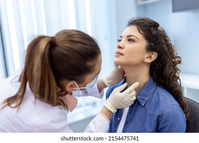 medicine, healthcare and medical exam concept - doctor or nurse checking patient's tonsils at hospital. Endocrinologist examining throat of young woman in clinic