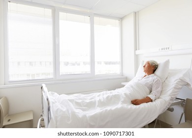 Medicine, Healthcare And Old People Concept - Sad Senior Woman Lying On Bed At Hospital Ward