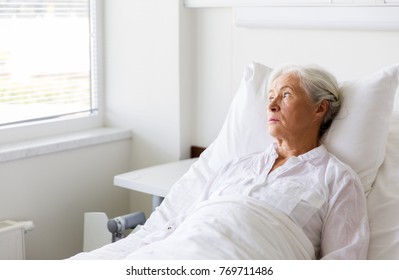 Medicine, Healthcare And Old People Concept - Sad Senior Woman Lying On Bed At Hospital Ward