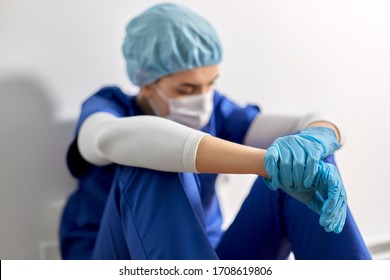 Medicine, Healthcare And Pandemic Concept - Sad Young Female Doctor Or Nurse Wearing Face Protective Mask For Protection From Virus Disease Sitting On Floor At Hospital