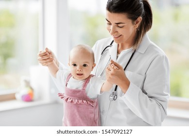 medicine, healthcare and pediatrics concept - female pediatrician or neuropathist doctor or nurse checking baby girl patient's health at clinic or hospital - Powered by Shutterstock