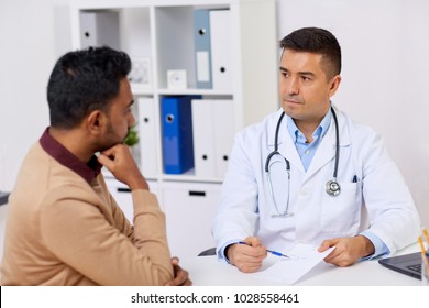 Medicine, Healthcare And People Concept - Doctor Showing Prescription To Male Patient At Clinic