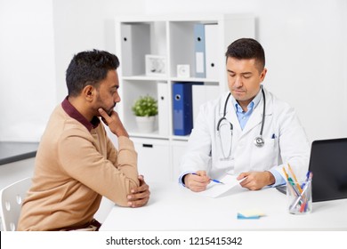 Medicine, Healthcare And People Concept - Doctor Showing Prescription To Male Patient At Clinic