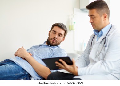 medicine, healthcare and people concept - doctor with tablet pc computer and young male patient having health problem meeting at hospital - Shutterstock ID 766025953