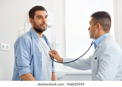 Medicine, Healthcare And People Concept - Doctor With Stethoscope Checking Patient Heart Beat Or Breath At Hospital