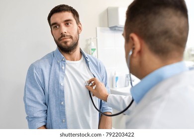 Medicine, Healthcare And People Concept - Doctor With Stethoscope Checking Patient Heart Beat Or Breath At Hospital