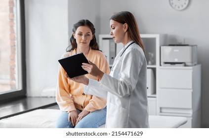medicine, healthcare and people concept - female doctor with tablet pc computer talking to woman patient at hospital