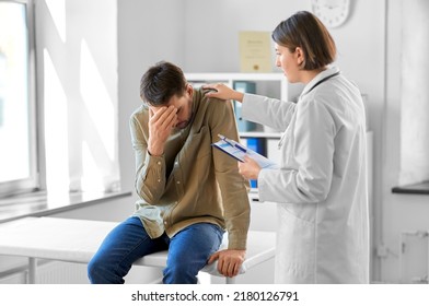 Medicine, Healthcare And People Concept - Female Doctor With Clipboard And Sad Male Patient Having Health Problem At Hospital