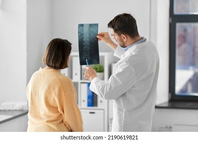 medicine, healthcare and people concept - male doctor showing x-ray to female patient at medical office in hospital - Powered by Shutterstock