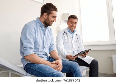 Medicine, Healthcare And People Concept - Smiling Doctor With Tablet Pc Computer And Young Man Patient Meeting At Hospital