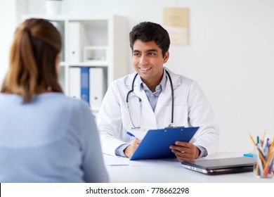 medicine, healthcare and people concept - smiling doctor with clipboard and patient at hospital