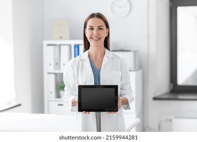 Medicine, Healthcare And Profession Concept - Smiling Female Doctor Showing Tablet Pc Computer With Empty Screen At Hospital