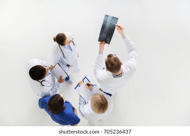 Medicine, Healthcare And Surgery Concept - Group Of Doctors Or Surgeons With Spine X-ray And Clipboards At Hospital