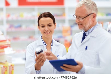 Medicine, Healthcare And Technology Concept - Apothecaries With Tablet Pc Computer And Medication At Pharmacy