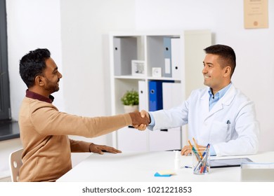 Medicine, Healthcare And Technology Concept - Doctor With And Male Patient Shaking Hands At Hospital