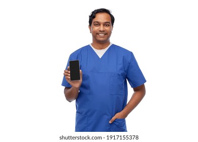 medicine, healthcare and technology concept - happy smiling indian doctor or male nurse in blue uniform with smartphone over white background - Powered by Shutterstock