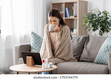 Medicine, Healthcare And Technology Concept - Sick Young Asian Woman Having Video Call Or Online Consultation On Tablet Pc Computer And Drinking Tea At Home