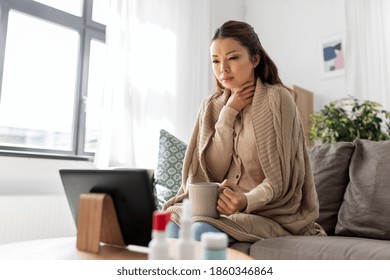 Medicine, Healthcare And Technology Concept - Sick Young Asian Woman Having Video Call Or Online Consultation On Tablet Pc Computer And Drinking Tea At Home