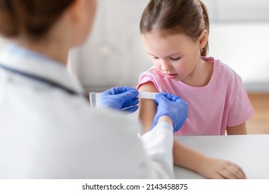 medicine, healthcare and vaccination concept - female doctor or pediatrician talking to little girl patient on medical exam at clinic - Powered by Shutterstock