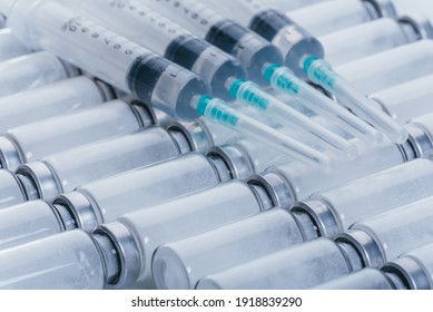 Medicine, Injection, vaccine and disposable syringe, drug concept. Sterile vial medical syringe needle. Macro close up. Glass medical ampoule vial for injection. Bottles ampule with aluminum cap.