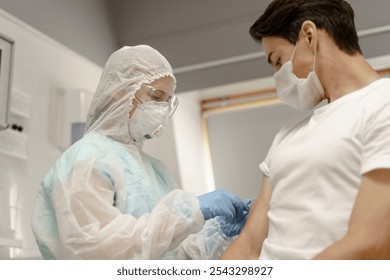 Medicine nurse at medical laboratory room. Hospital female employee injects corona virus vaccine in hand. Indoors shot of biochemistry for therapy covid-19 infection at doctor office with equipment - Powered by Shutterstock