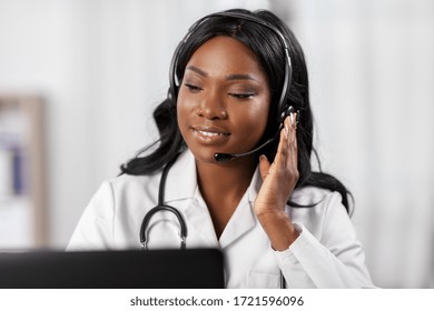 Medicine, Online Service And Healthcare Concept - Happy Smiling African American Female Doctor Or Nurse With Headset And Laptop Having Conference Or Video Call At Hospital