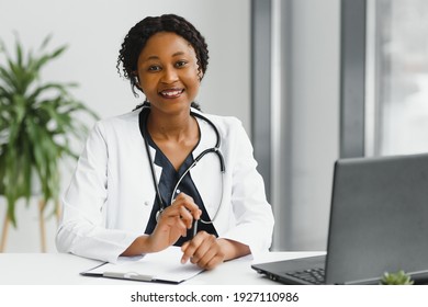 Medicine, Online Service And Healthcare Concept - Happy Smiling African American Female Doctor Or Nurse With Headset And Laptop Having Conference Or Video Call At Hospital