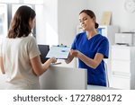 medicine, people and healthcare concept - female doctor or nurse with clipboard and patient at hospital