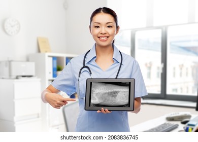 Medicine, Pet And Healthcare Concept - Happy Smiling Veterinarian Doctor Showing Animal's X-ray On Tablet Pc Computer Over Vet Clinic Office Background