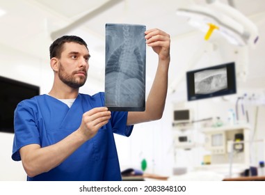 Medicine, Pet And Healthcare Concept - Male Veterinarian Doctor Looking At Animal's X-ray Over Vet Clinic Office Background