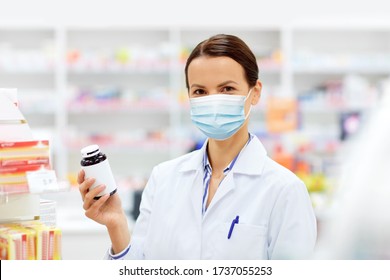 Medicine, Pharmaceutics And Healthcare Concept - Happy Female Apothecary Wearing Face Protective Medical Mask For Protection From Virus Disease With Drug At Pharmacy