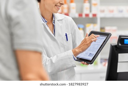 Medicine, Pharmaceutics, Healthcare And Technology Concept - Close Up Of Smiling Female Pharmacist Showing Digital Prescription On Tablet Pc Computer To Customer At Pharmacy