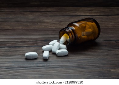 medicine pill tablet with spilled bottle on wooden table