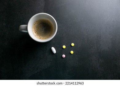Medicine pills next to a cup to take with breakfast. Mention of medical choices, risks of medication in conjunction with coffee, misunderstanding of prescriptions, self-medication Alternative medicine