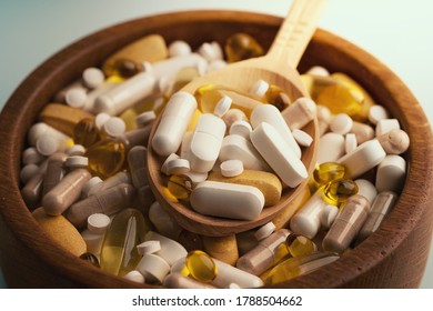 Medicine pills, tablets and different drugs in wooden bowl with spoon.