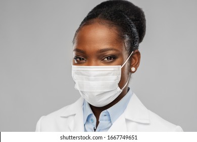 Medicine, Profession And Healthcare Concept - African American Female Doctor Or Scientist In Protective Facial Mask Over Grey Background