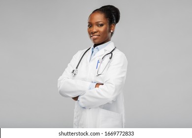 medicine, profession and healthcare concept - happy smiling african american female doctor in white coat with stethoscope over background - Powered by Shutterstock