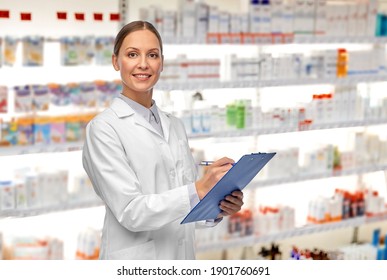 medicine, profession and healthcare concept - happy smiling female doctor or pharmacist in white coat with clipboard and pen writing medical report over pharmacy background