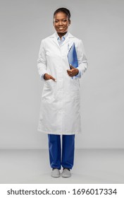 Medicine, Profession And Healthcare Concept - Smiling African American Female Doctor Or Scientist In White Coat Witch Clipboard Over Grey Background