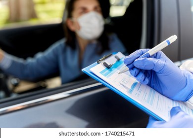 medicine, quarantine and pandemic concept - close up of doctor or healthcare worker in protective medical gloves writing to clipboard and woman waiting for coronavirus test in her car