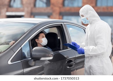 Medicine, Quarantine And Pandemic Concept - Doctor Or Healthcare Worker In Protective Gear Or Hazmat Suit, Medical Mask, Gloves And Goggles With Clipboard And Woman In Car Waiting For Coronavirus Test