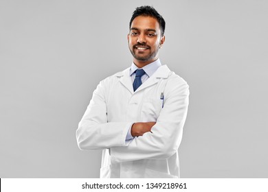 medicine, science and profession concept - smiling indian male doctor or scientist in white coat over grey background