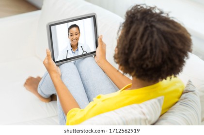 Medicine, Technology And Healthcare Concept - African Young Female Patient Having Video Chat With Doctor On Tablet Pc Computer At Home