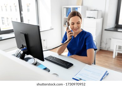 Medicine, Technology And Healthcare Concept - Female Doctor Or Nurse With Computer And Clipboard Calling On Phone At Hospital