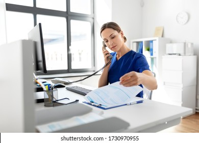 Medicine, Technology And Healthcare Concept - Female Doctor Or Nurse With Computer And Clipboard Calling On Phone At Hospital