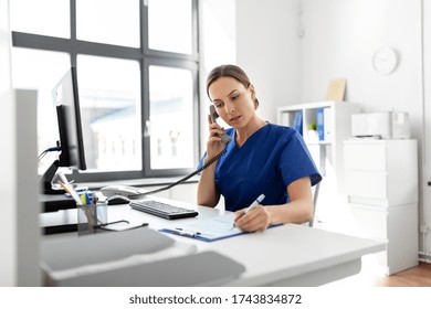 Medicine, Technology And Healthcare Concept - Female Doctor Or Nurse With Computer And Clipboard Calling On Phone At Hospital