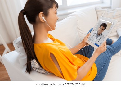 Medicine, Technology And Healthcare Concept - Happy Asian Woman Or Patient Having Video Chat With Doctor On Tablet Pc Computer At Home